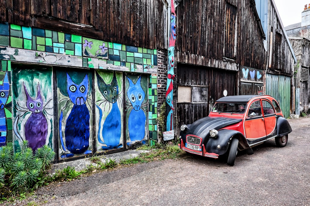 black car parked beside blue and white painted wall