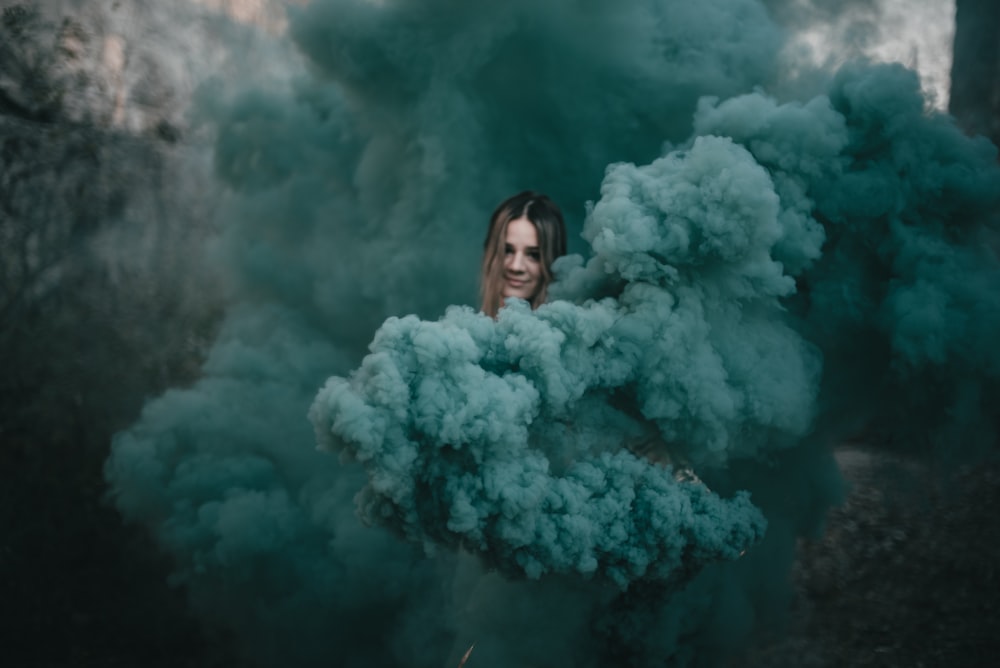 mujer con abrigo de piel blanca de pie frente al humo blanco