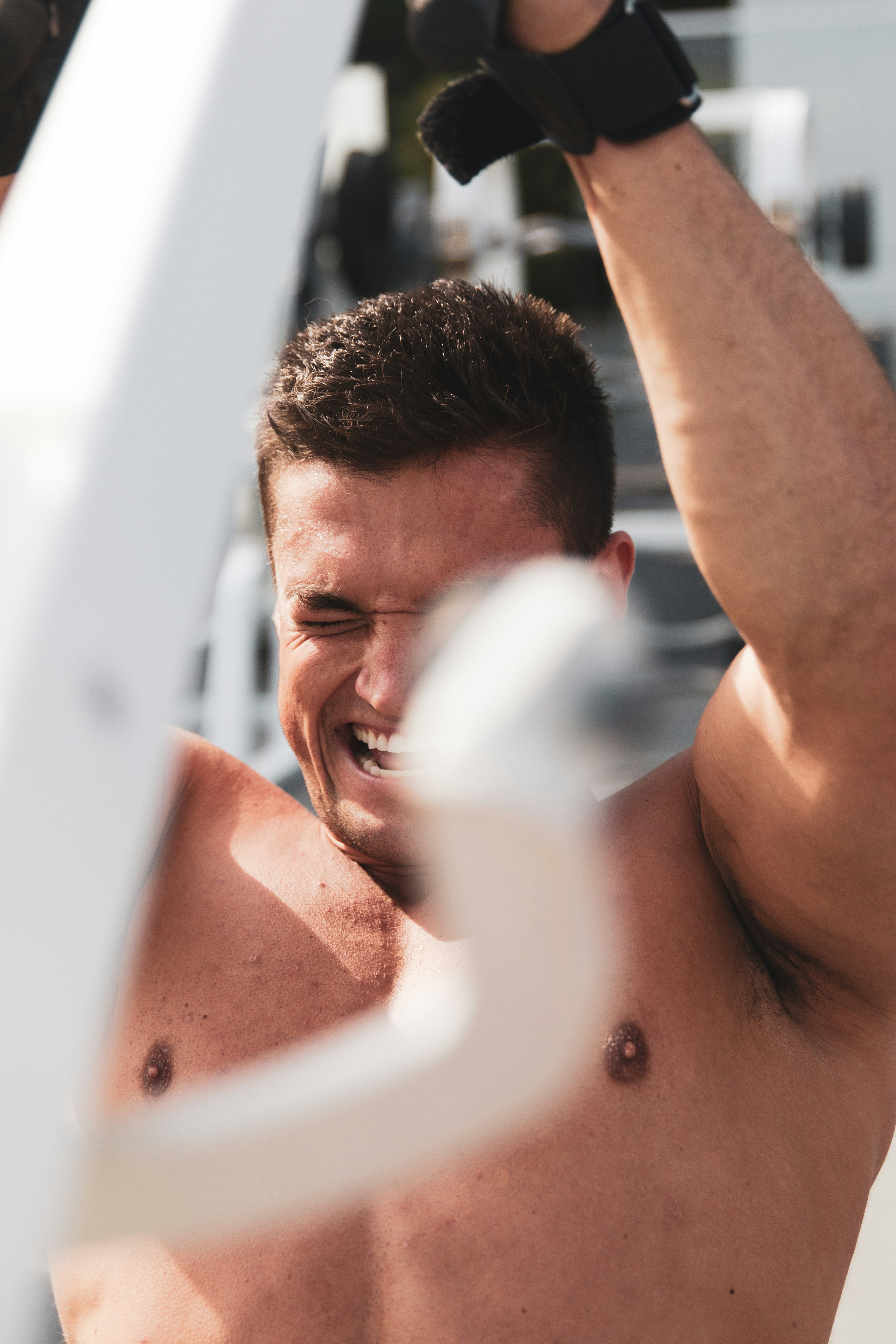 Muscular man lifting heavy weights during an intense squat session inside a gym.
