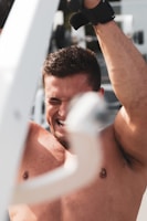 Close-up of hands gripping gym equipment, beads of sweat showing effort.