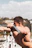 A focused man exercising on parallel bars in a sunny park.