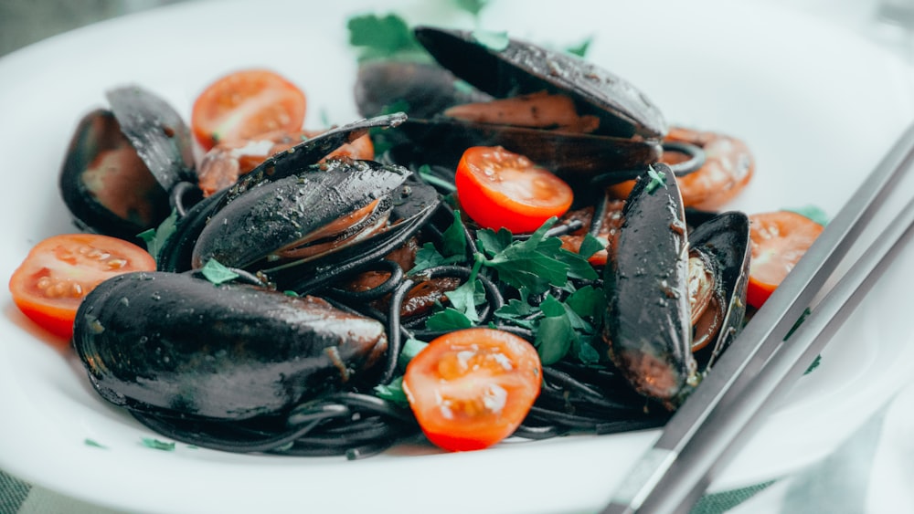 schwarze und rot geschnittene Tomaten auf schwarzem Keramikteller