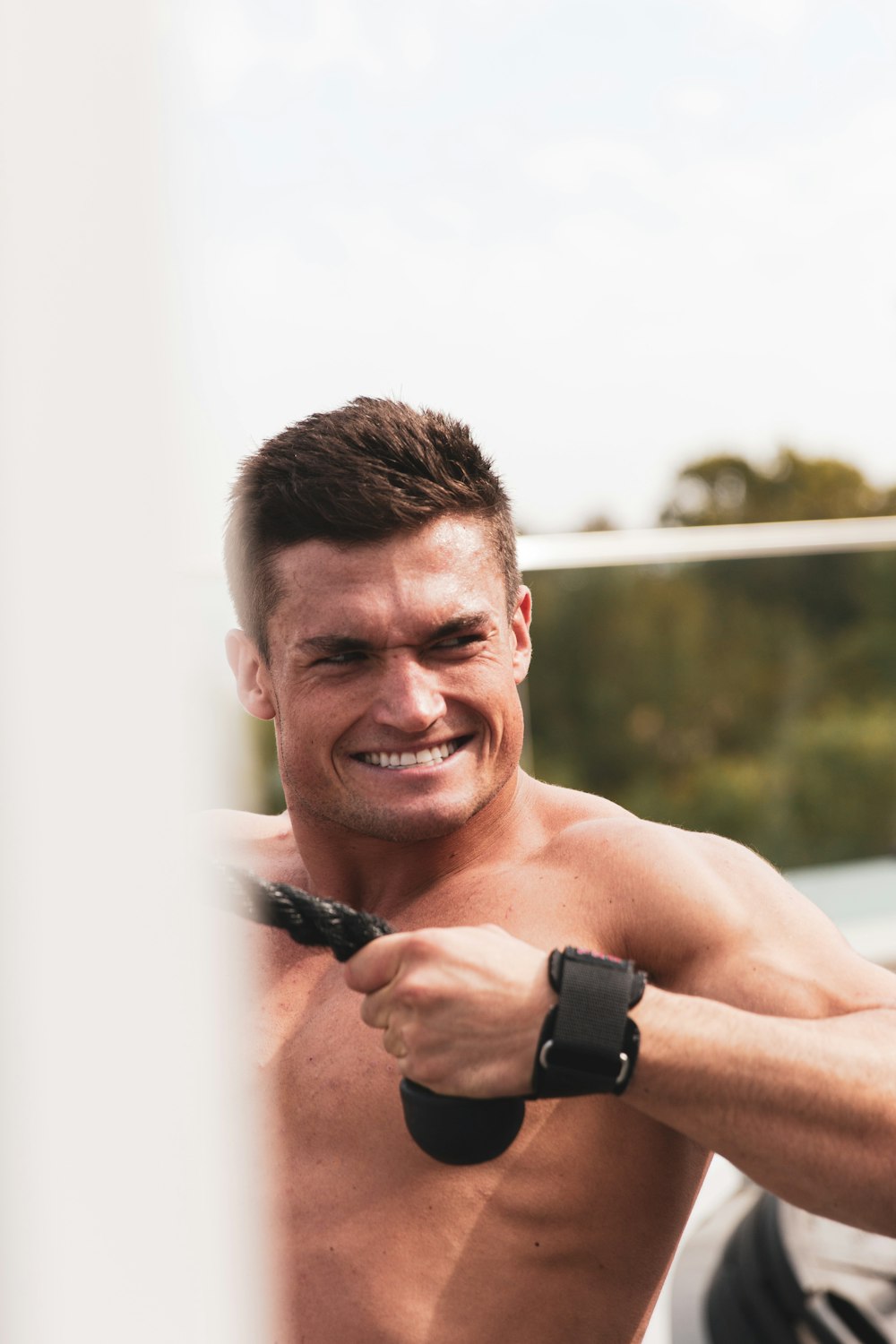 topless man wearing black watch smiling