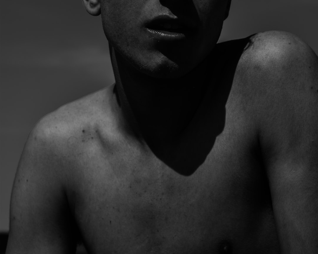 topless man in grayscale photography