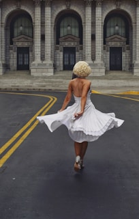 A joyful woman twirling in a casual chic outfit on a city street