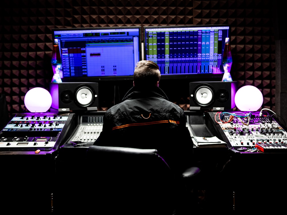 man in black jacket sitting in front of computer