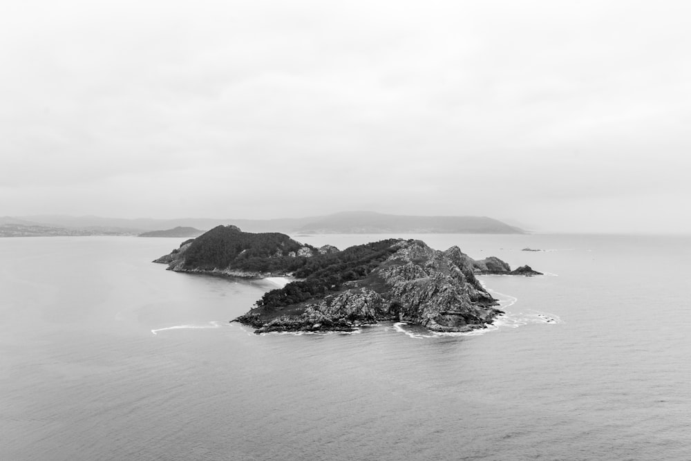 grayscale photo of mountain near body of water