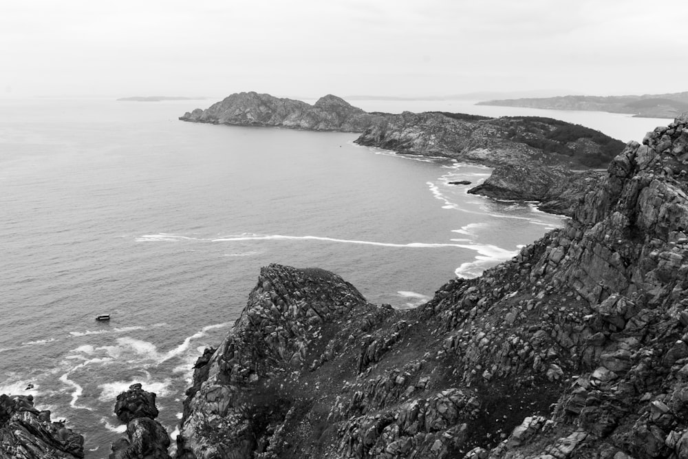 grayscale photo of sea and mountain