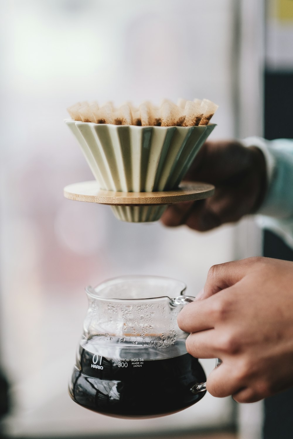 person pouring milk on clear glass mug