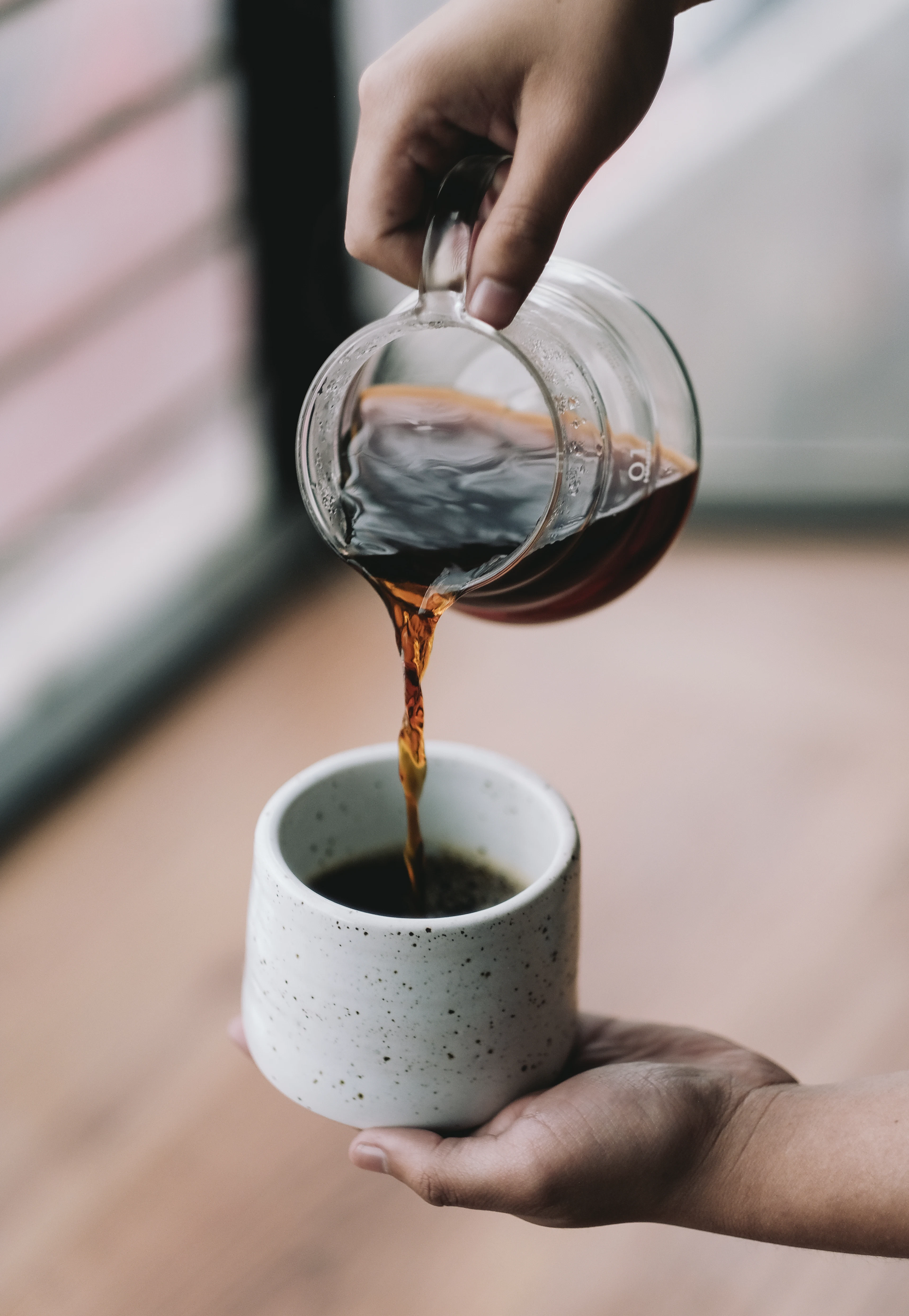 Filter coffee poured from a glass carafe into a mug