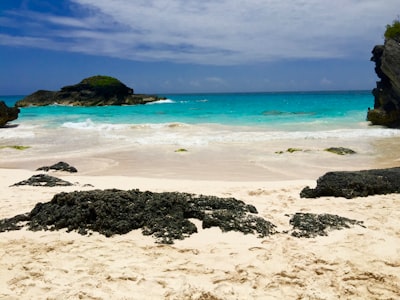 black rock formation on sea shore during daytime bermuda teams background