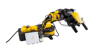 A robotic arm featuring several joints and grippers, connected to a control box. The arm is yellow with black accents, and visible wires help control its movements. Mounted on a base, it also includes a circuit board with 'Flick' branding.