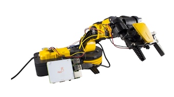 A robotic arm featuring several joints and grippers, connected to a control box. The arm is yellow with black accents, and visible wires help control its movements. Mounted on a base, it also includes a circuit board with 'Flick' branding.