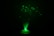 A fiber optic lamp emits an array of glowing green lights. The slender fibers fan out from the base, creating an enchanting display of shimmering green points that contrast with the darkness around.