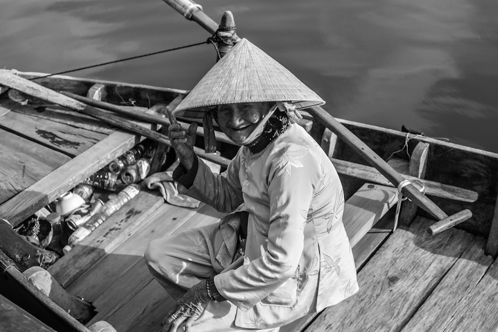 man in white long sleeve shirt sitting on wooden boat