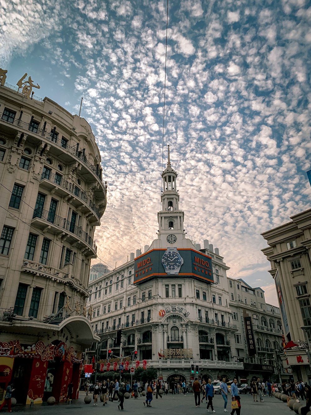 edifício de concreto branco com torre do relógio sob o céu azul durante o dia