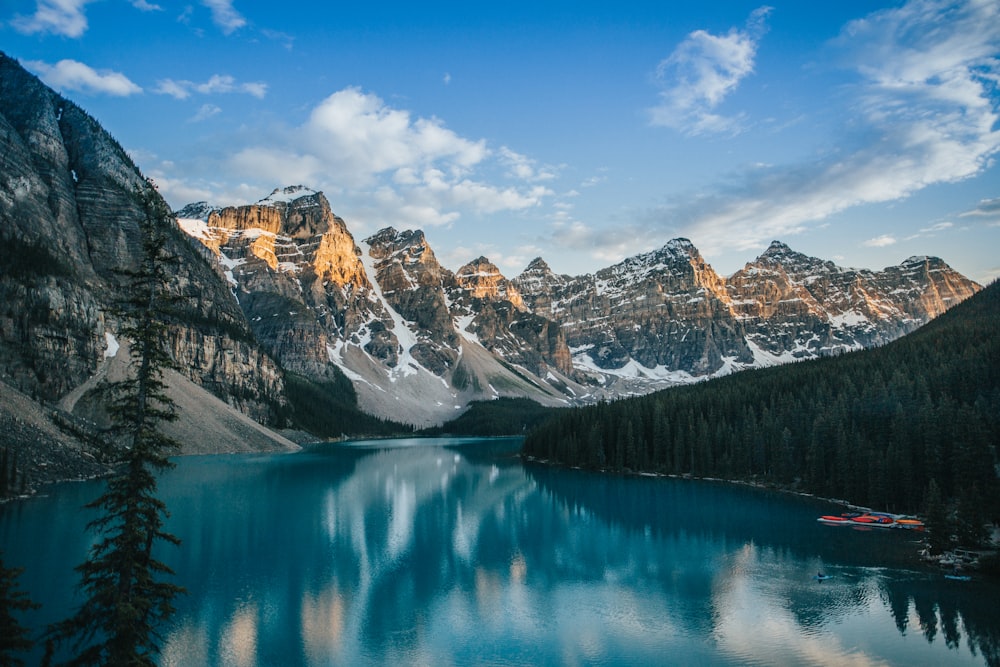 lake near snow covered mountain under blue sky during daytime