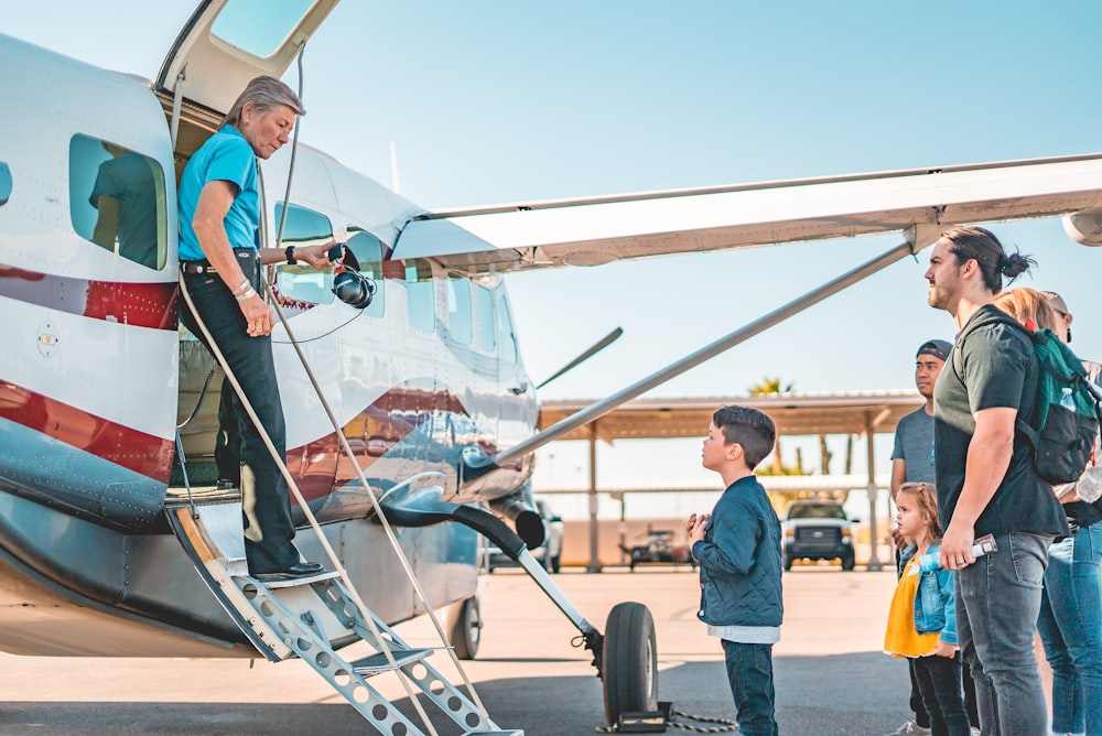 man in blue polo shirt and black pants riding on white and black helicopter during daytime