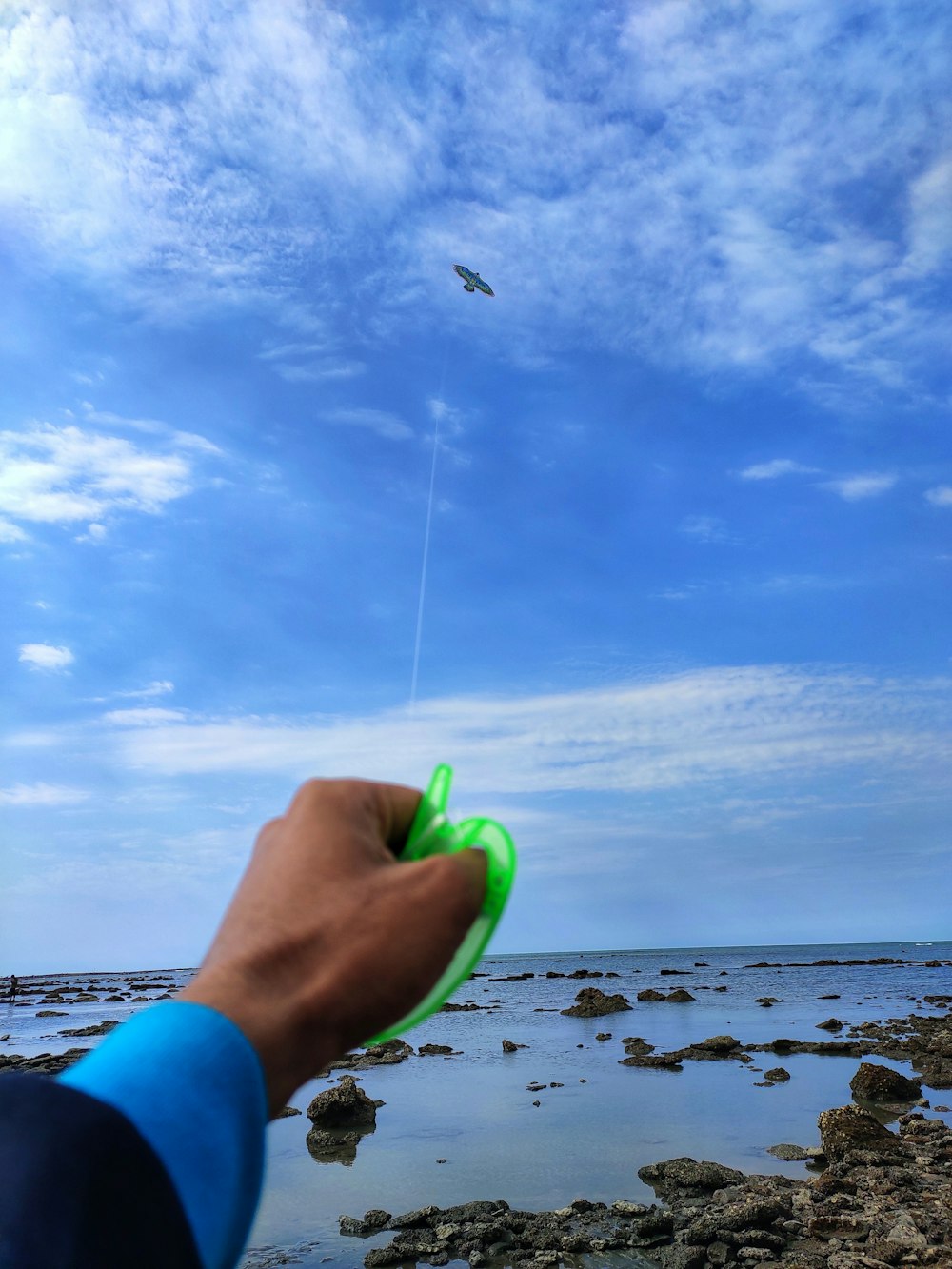 person holding green and blue plastic toy