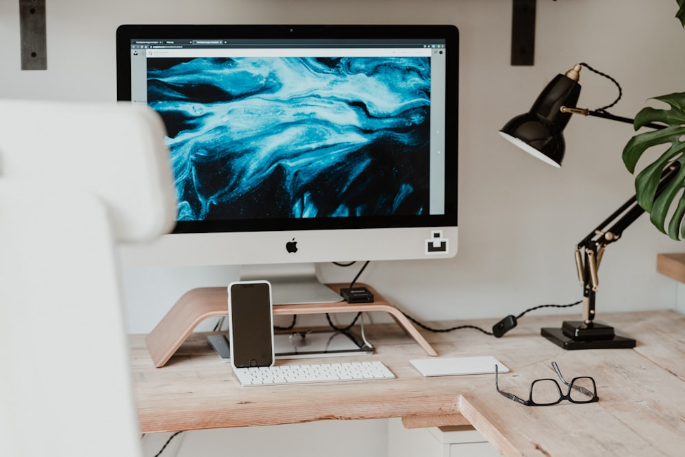 silver imac on brown wooden desk