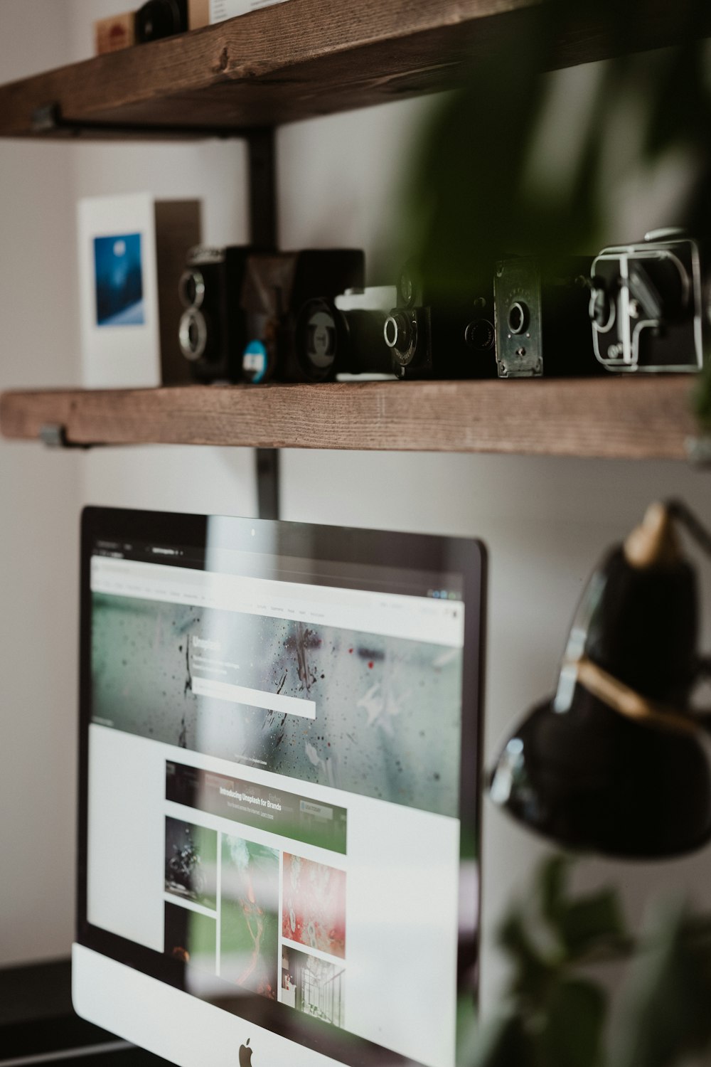 black and silver camera on brown wooden shelf