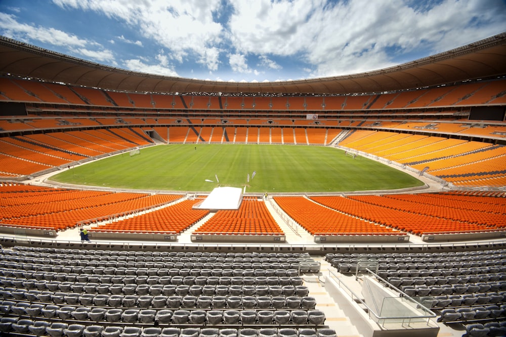 brown and green football field under blue sky during daytime