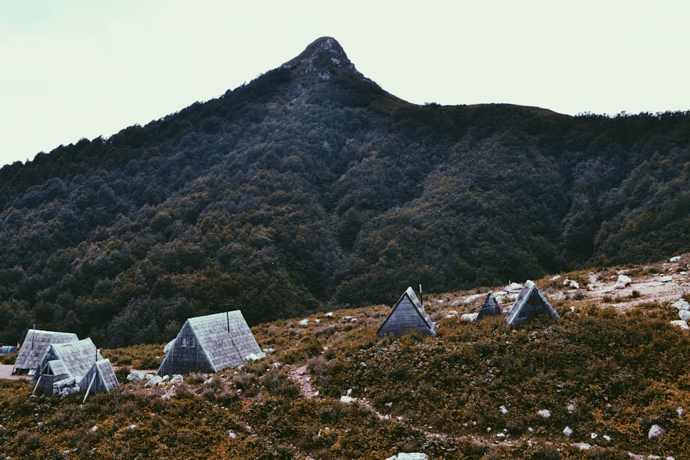 piramide grigia sul campo di erba verde vicino alla montagna durante il giorno