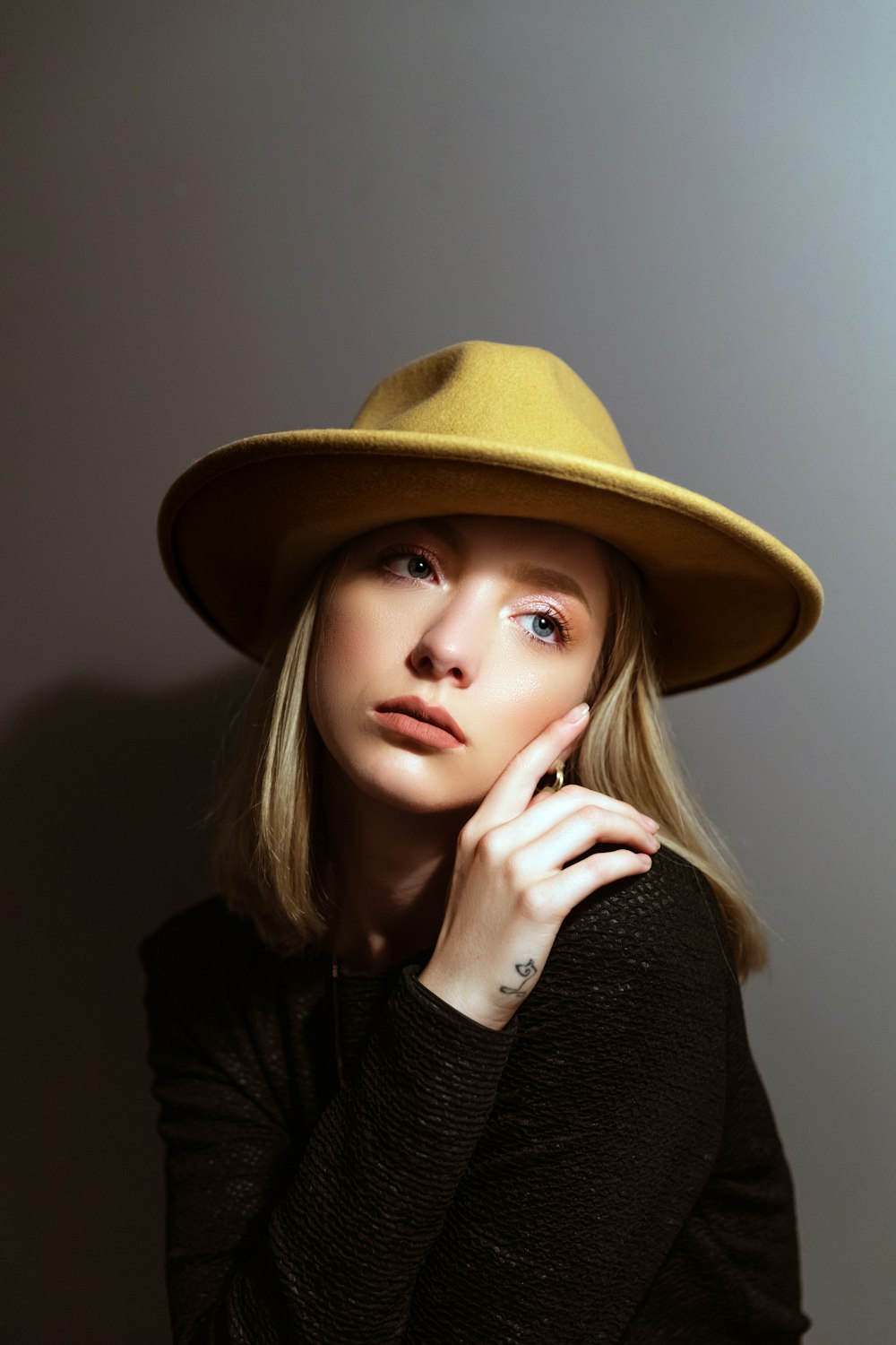 woman in black long sleeve shirt wearing brown hat