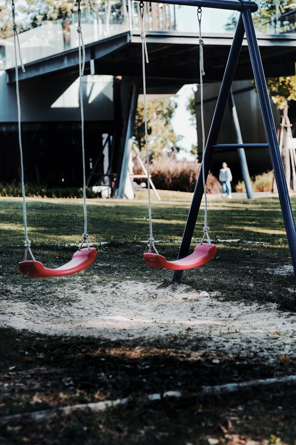 red and black swing on brown soil during daytime