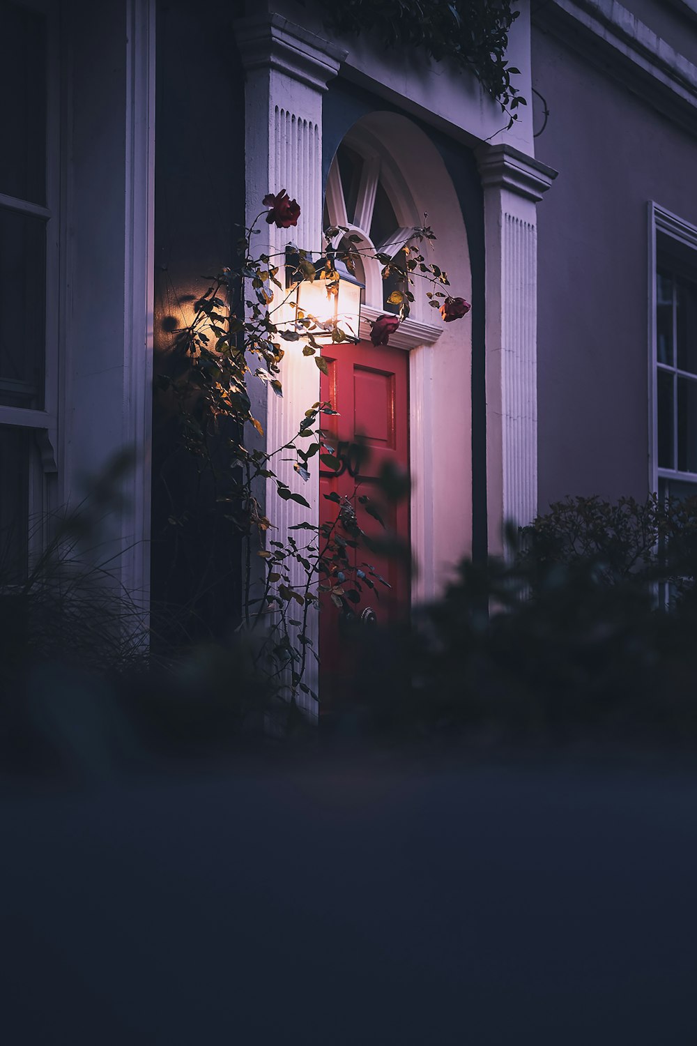 white wooden door with red and white floral curtain