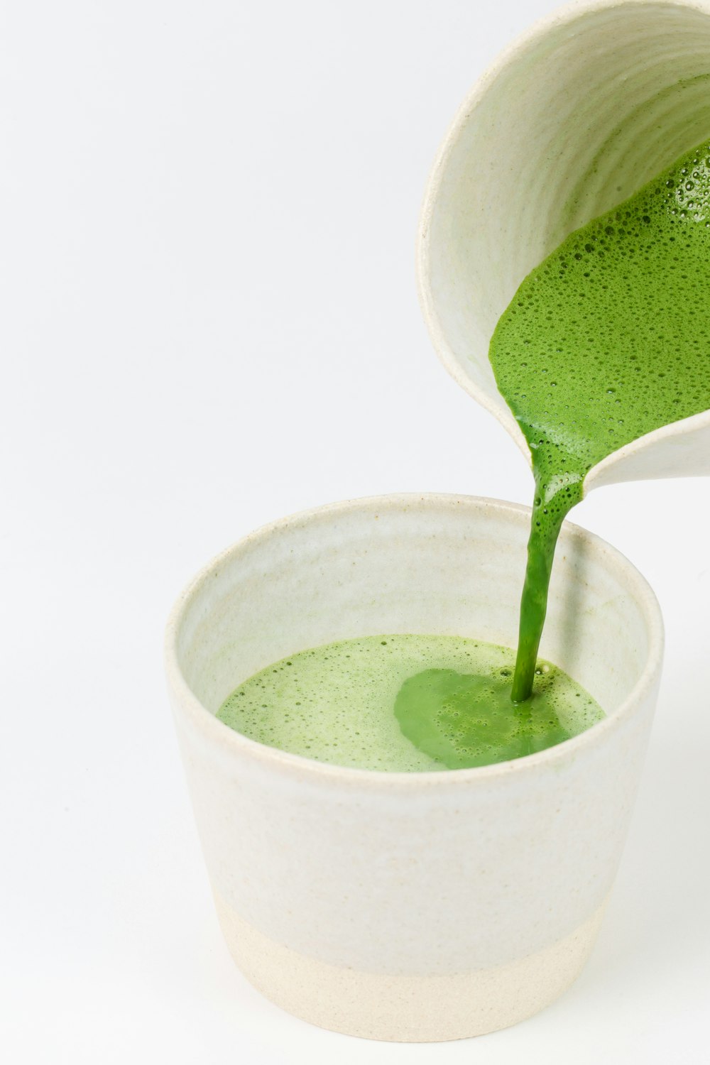 Líquido verde en vaso de cerámica blanca
