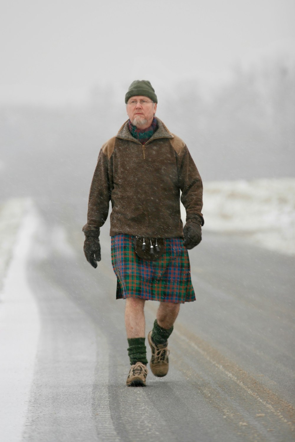 man in brown jacket standing on road