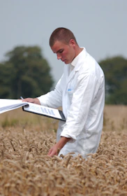 man in white dress shirt reading book