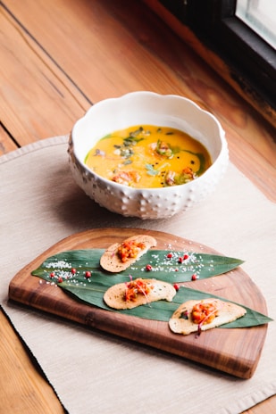 A vibrant bowl of steaming Creole gumbo garnished with fresh herbs on a rustic wooden table.