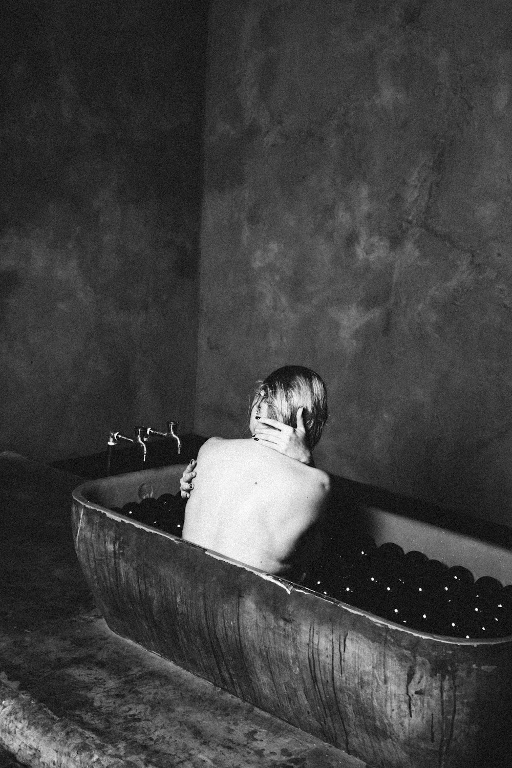 topless child in bathtub grayscale photo