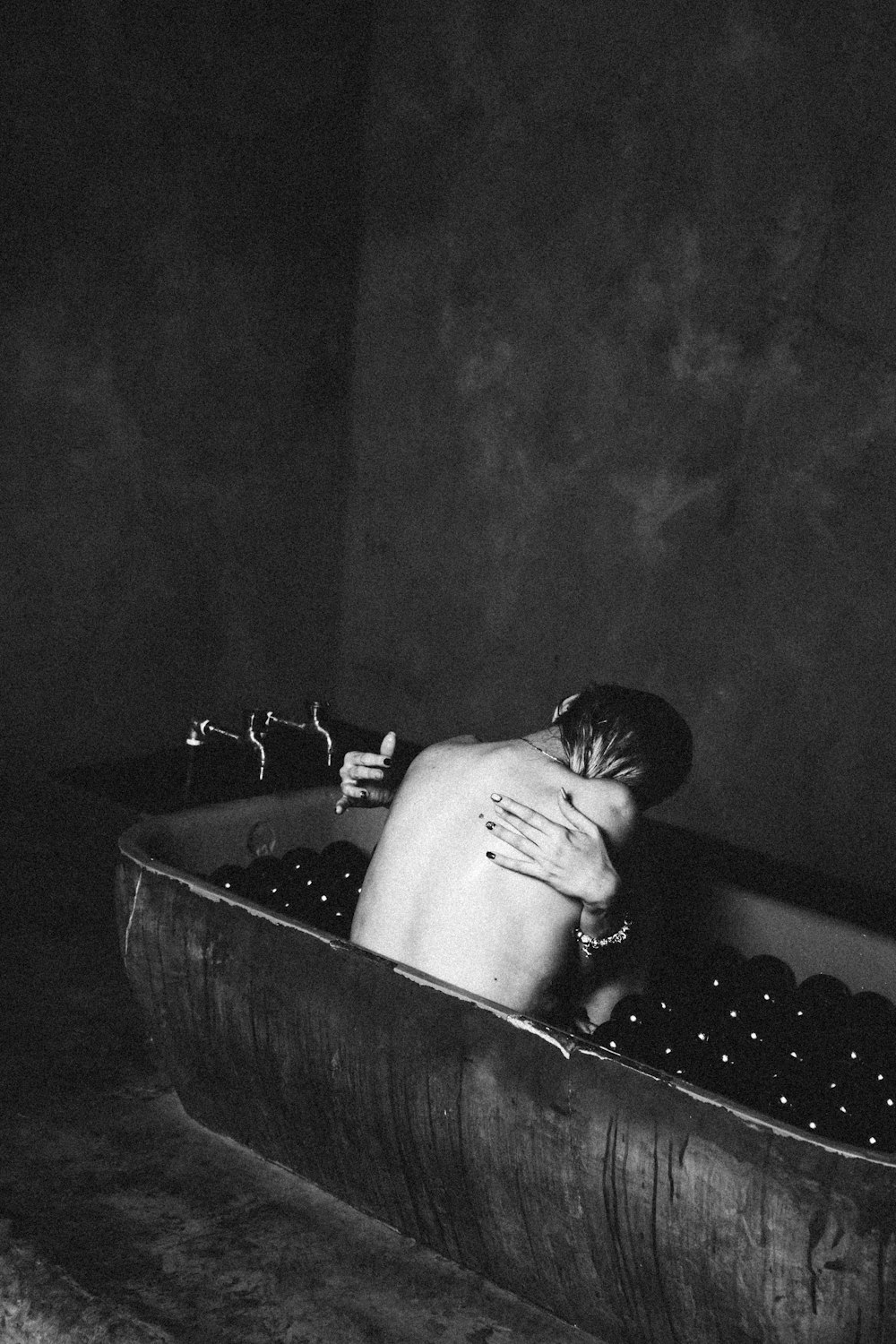 topless man in bathtub with water
