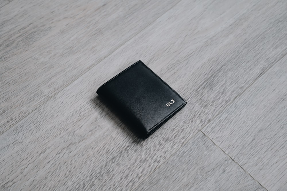 black leather bifold wallet on brown wooden table