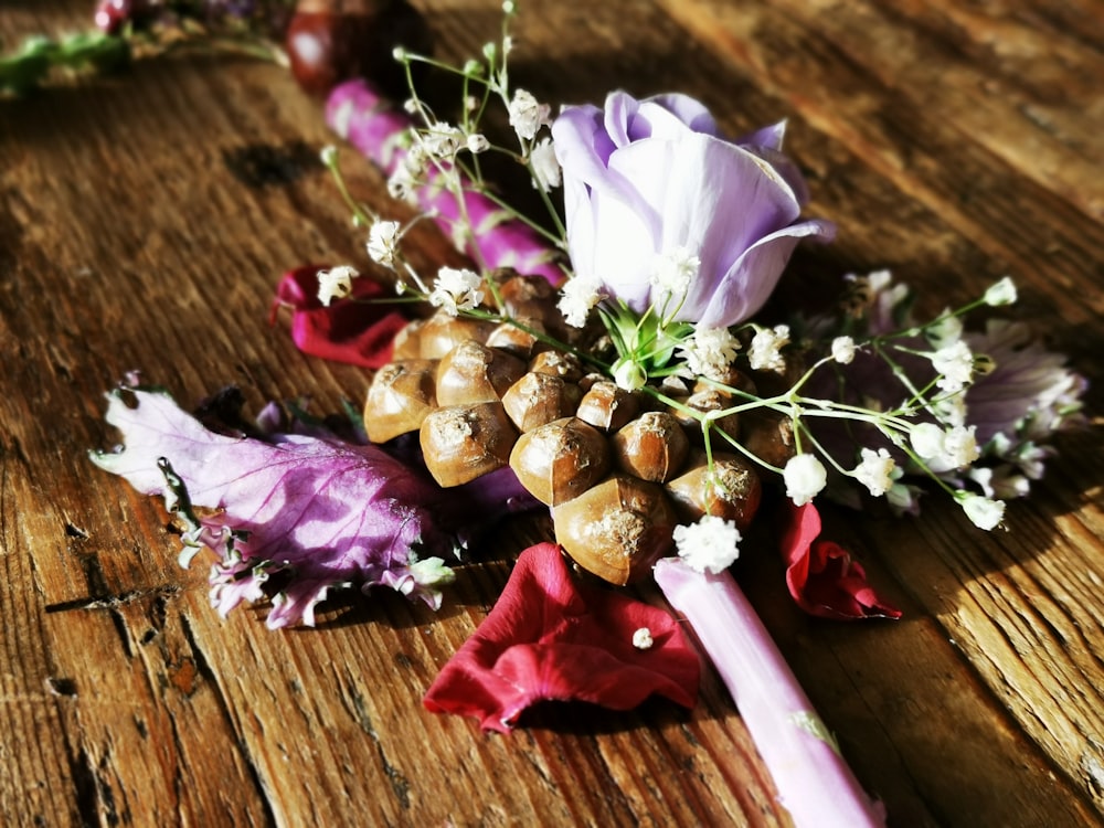 white and purple flower on brown wooden table