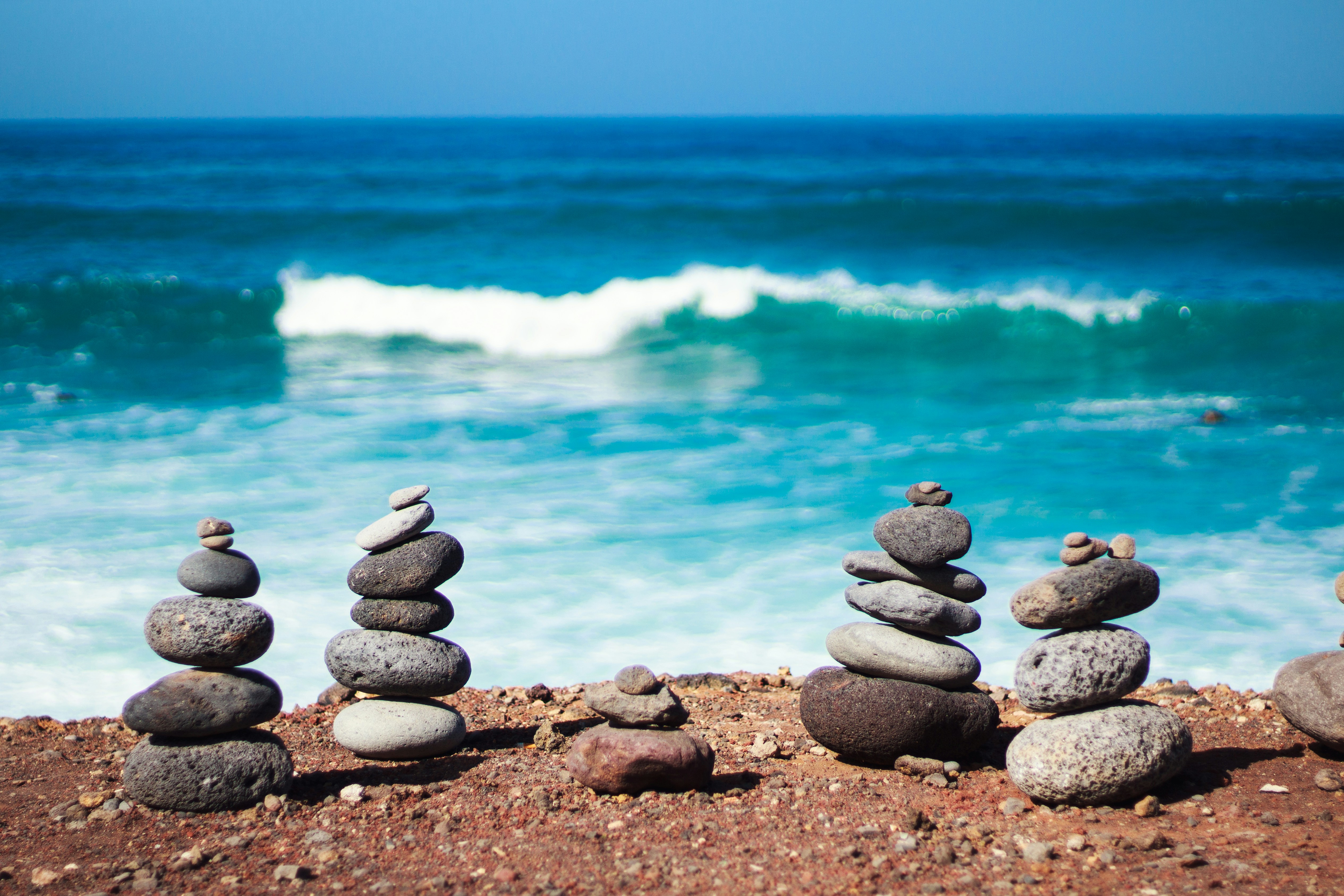 gray and black stones near body of water during daytime