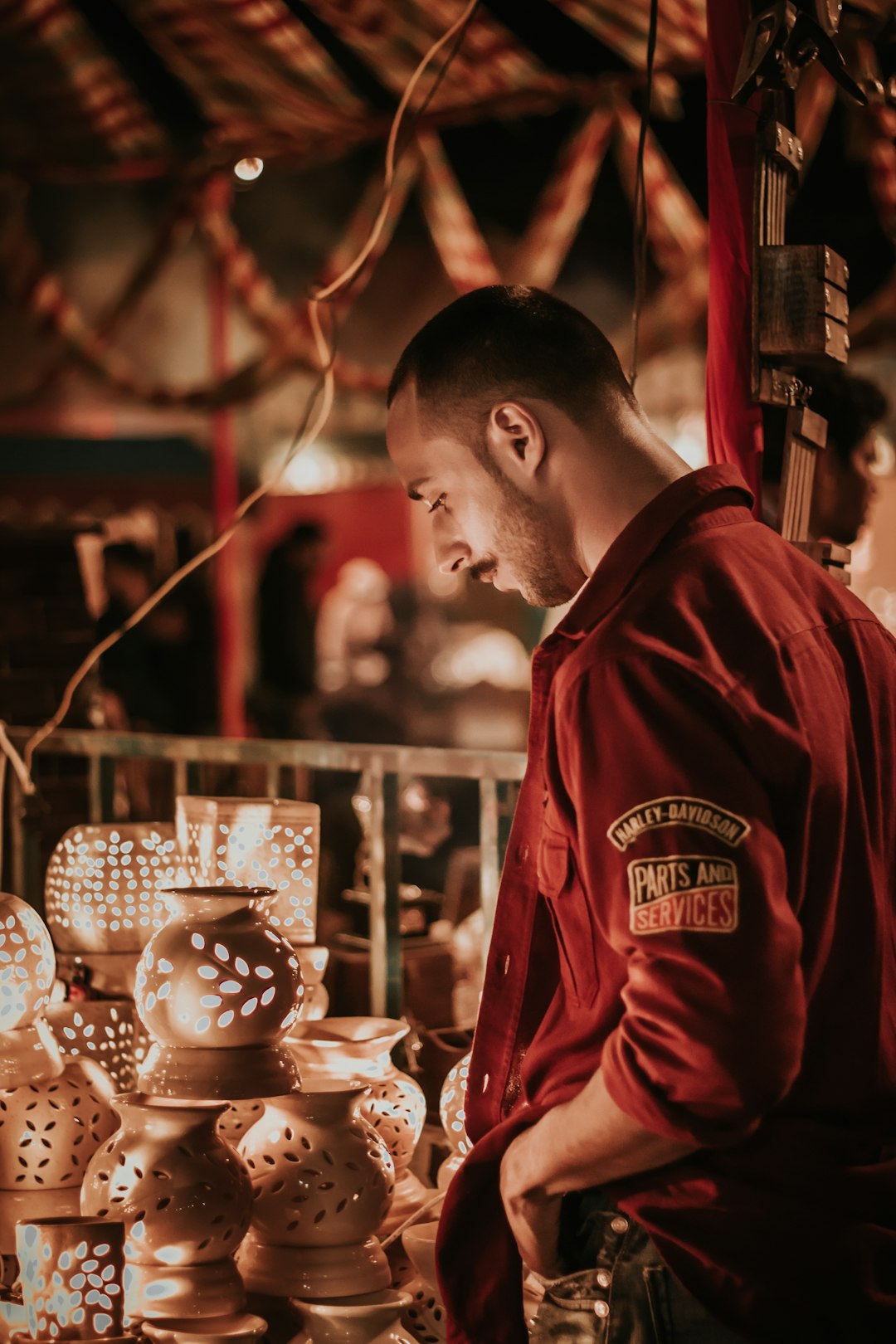 man in red hoodie standing near lighted candle