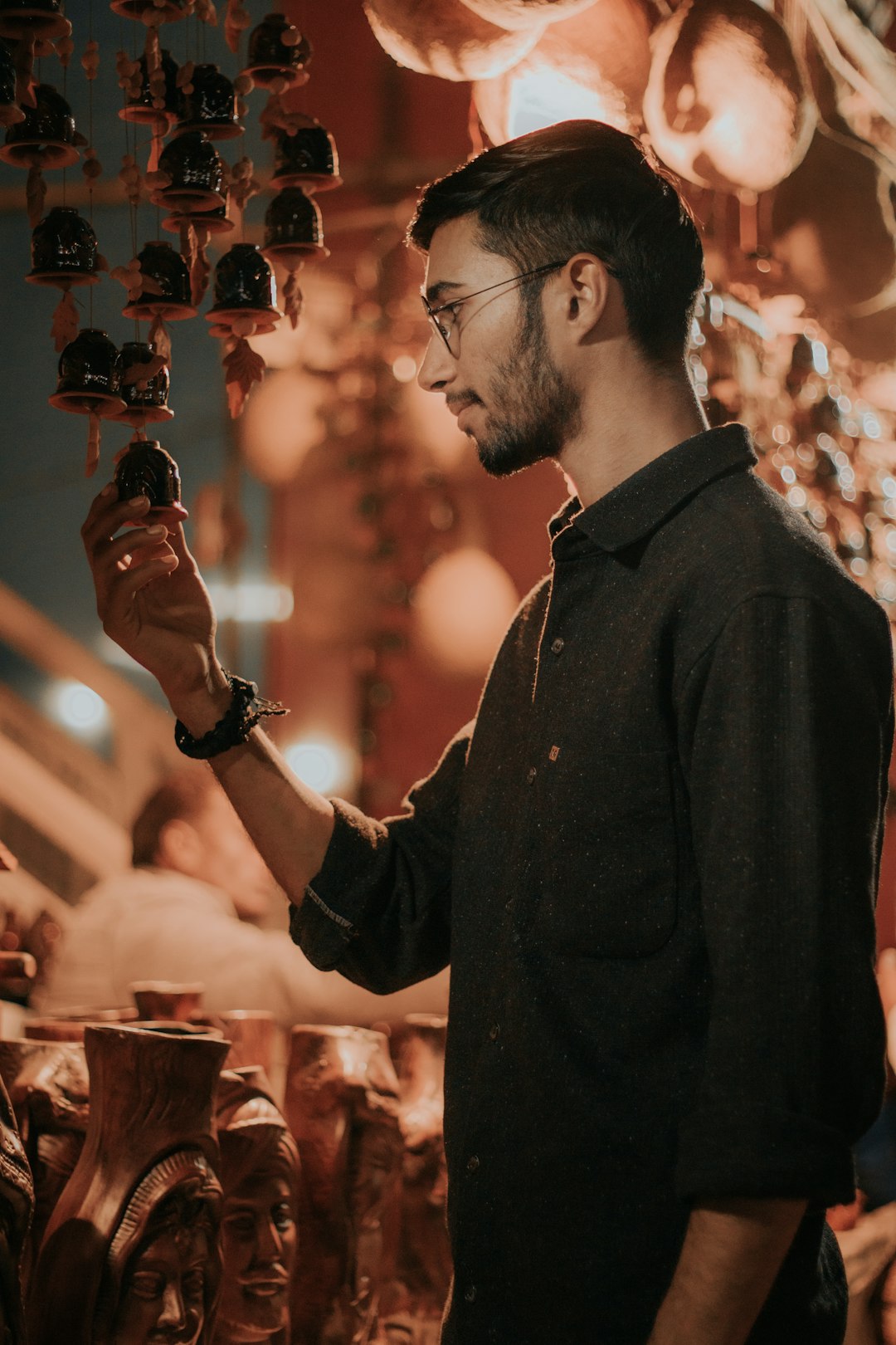 man in black button up long sleeve shirt holding black smartphone