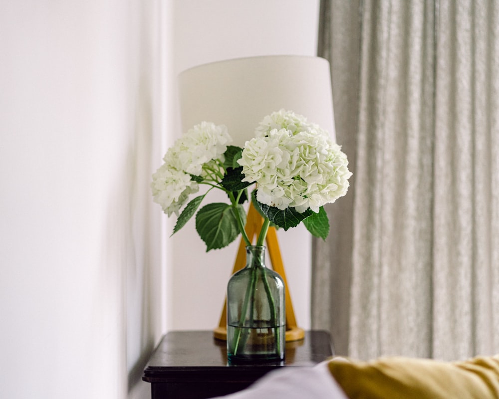 white flowers in glass vase on table