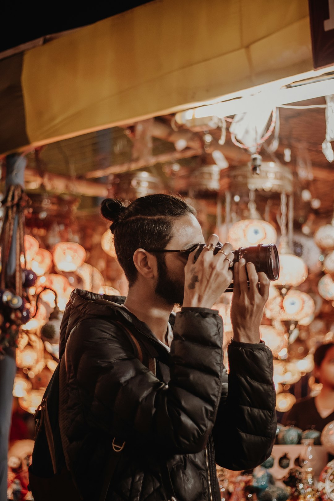 man in black leather jacket taking photo of people during nighttime