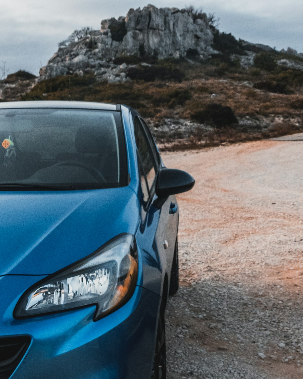 blue honda car on brown field during daytime