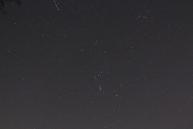 A night sky filled with constellations over a glowing stock chart.