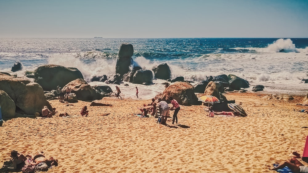 pessoas sentadas na praia durante o dia