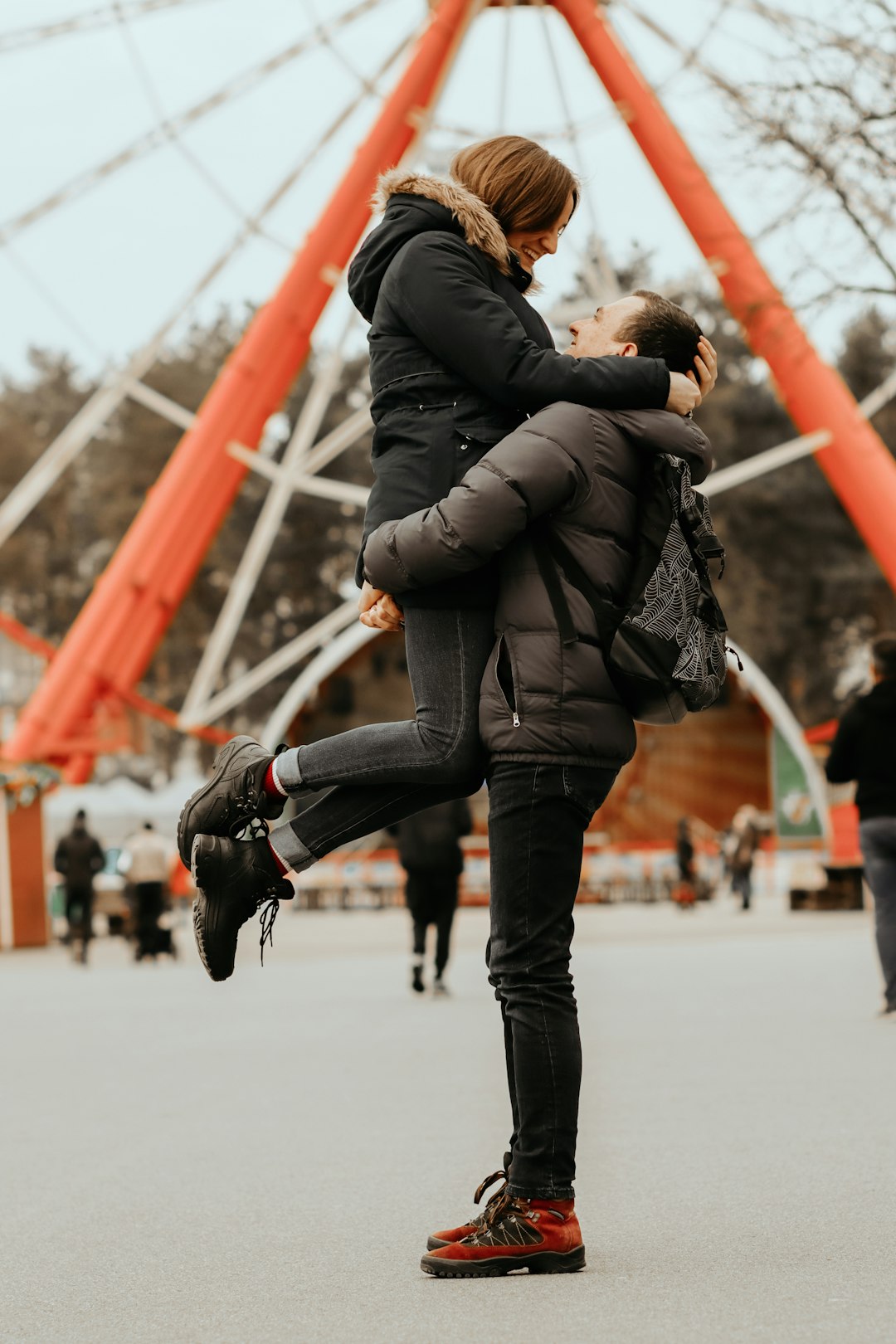 woman in black jacket and blue denim jeans with black short coat dog jumping on air