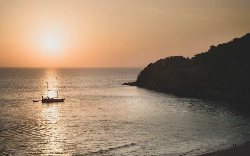 silhouette of boat on sea during sunset