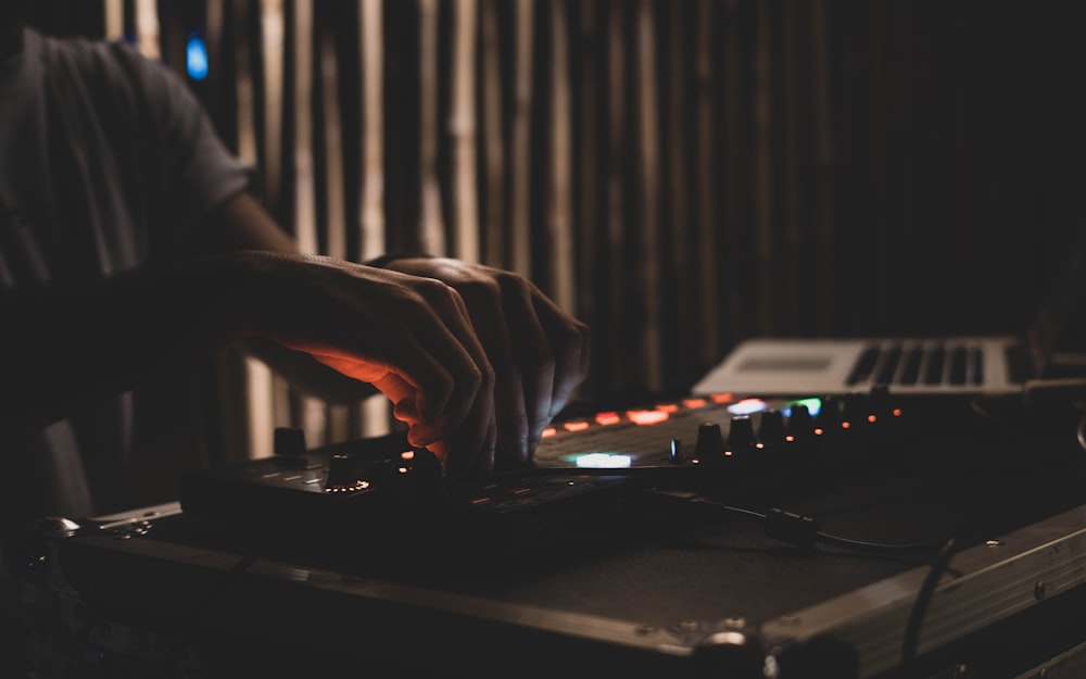 person playing dj mixer in room