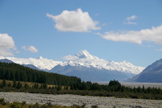 green trees and mountain under blue sky and white clouds during daytime in Lake Pukaki New Zealand